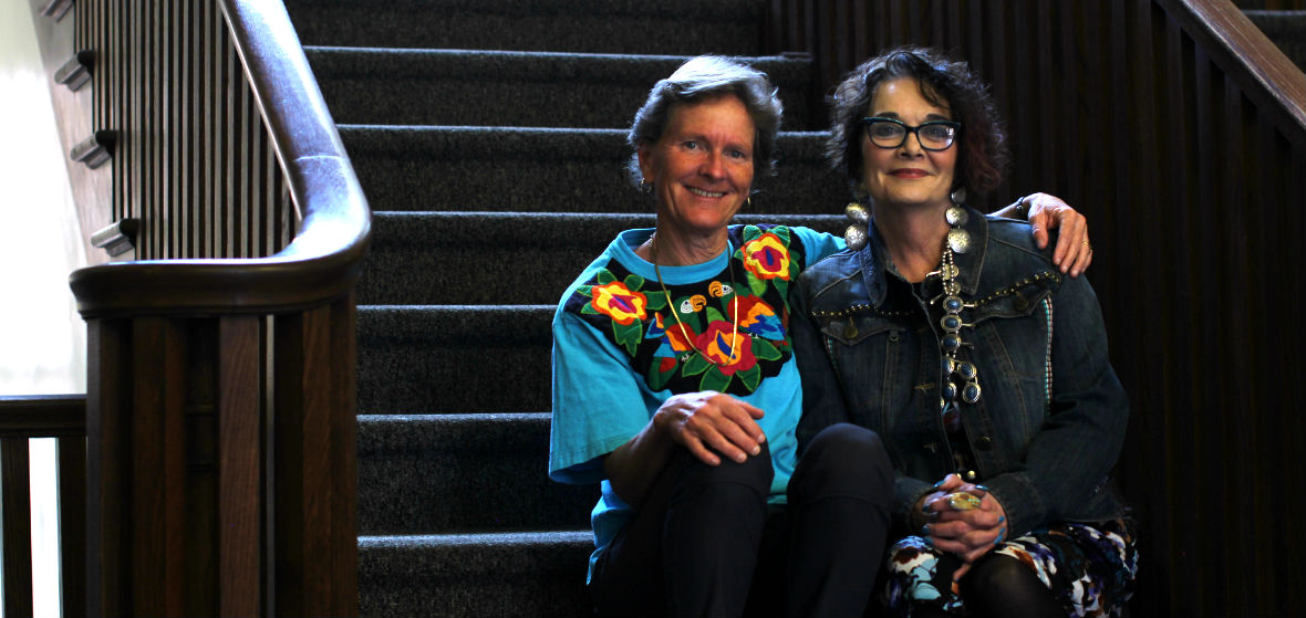 Cheryll Glotfelty and Gailmarie Pahmeier sit together on stairs